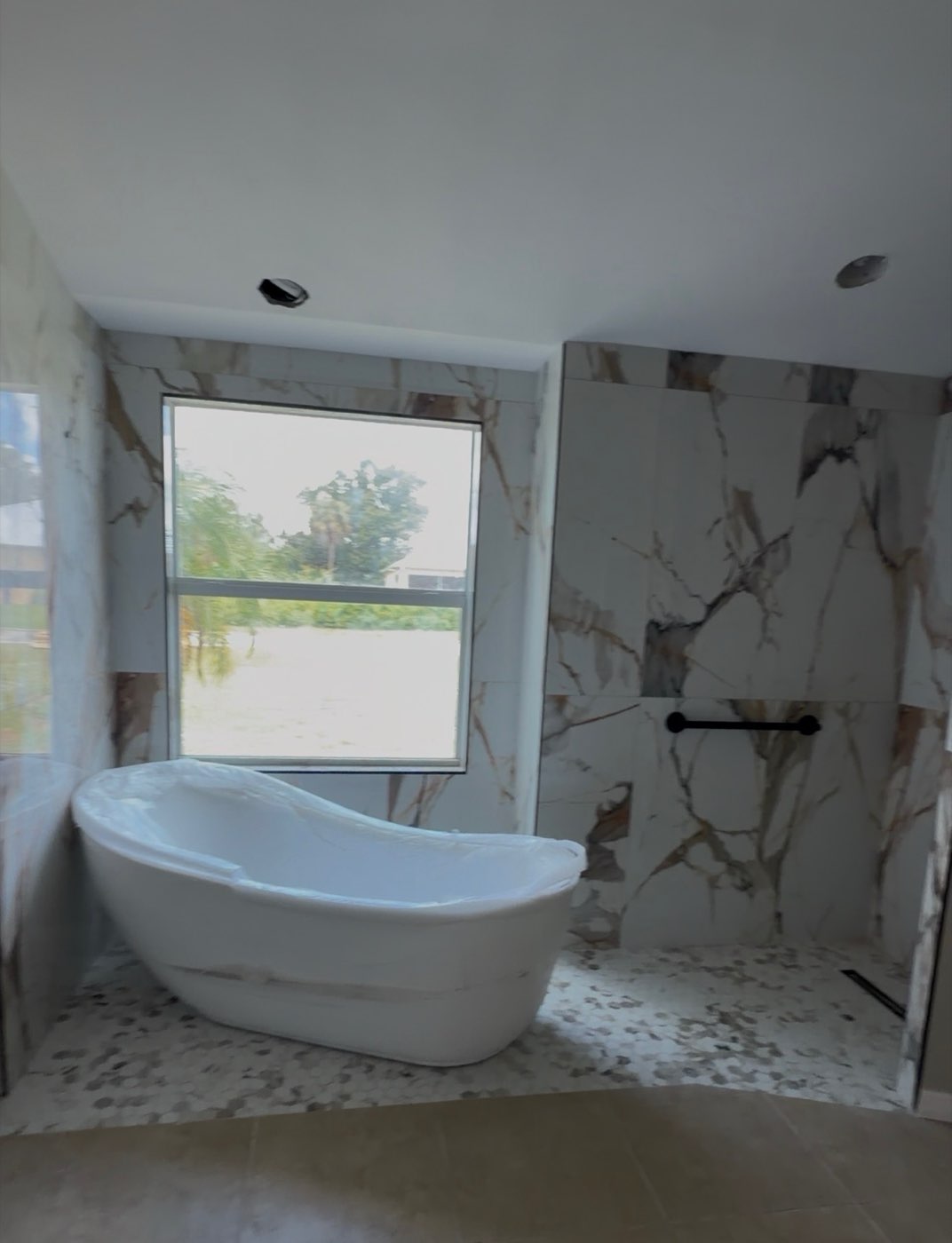 Freestanding tub with marble-look tile surround
