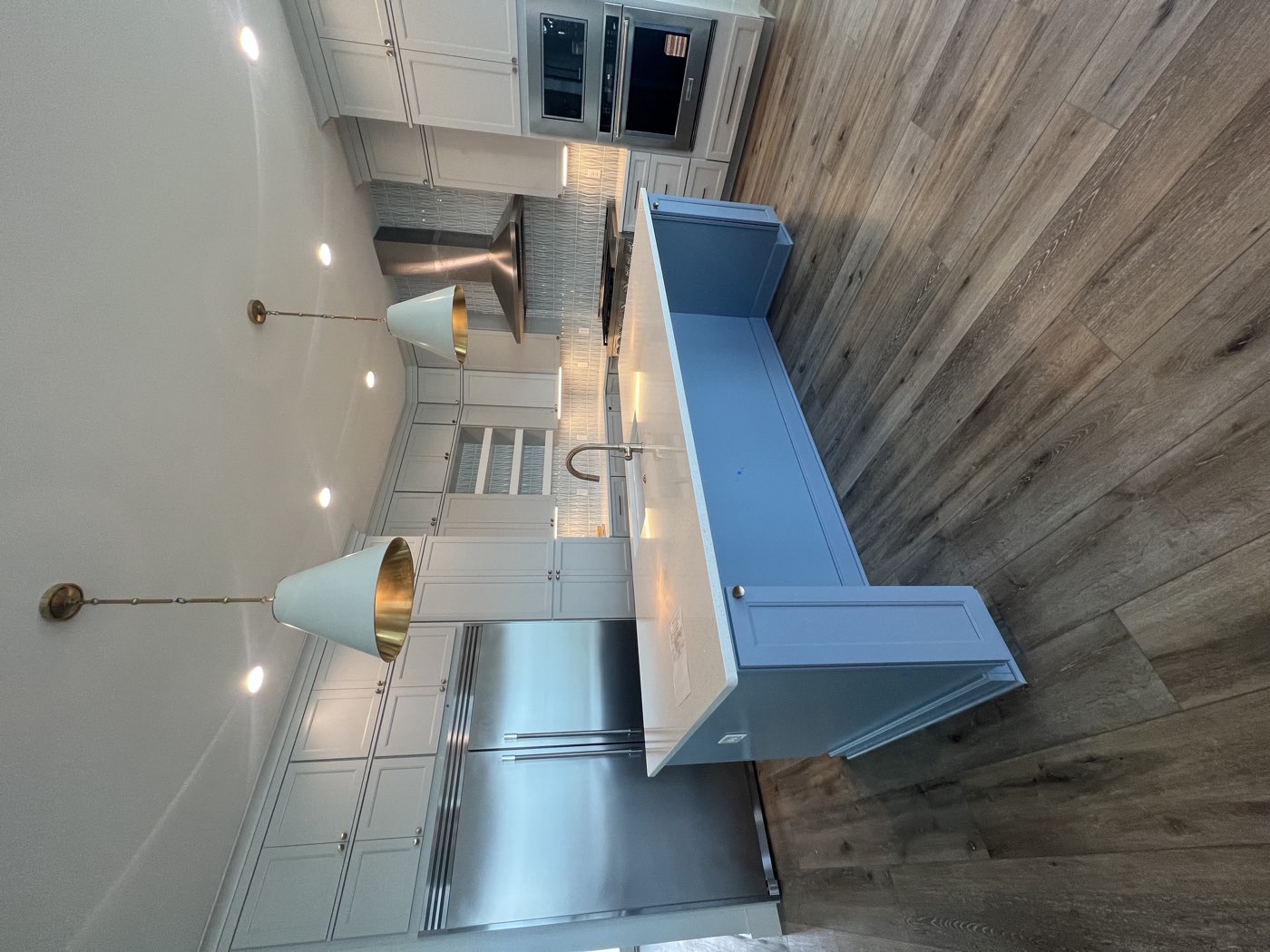 Kitchen remodel with a blue island and stainless appliances